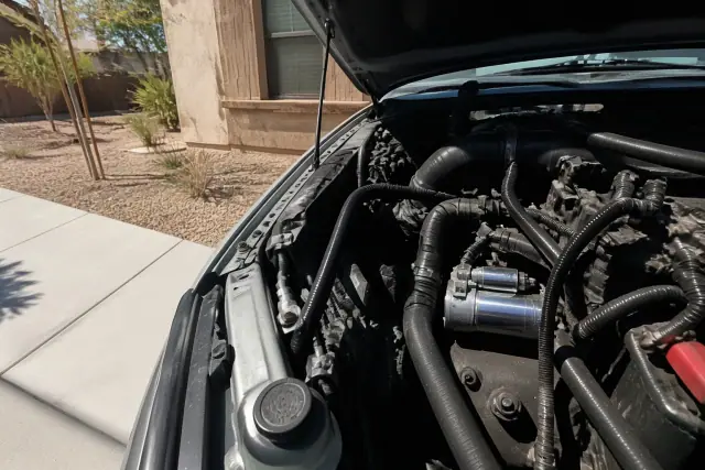 New car starter installed in a vehicle engine bay at a home driveway in Surprise, AZ.