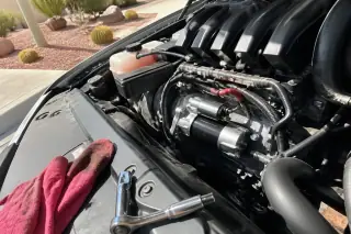 Socket wrench and mechanic rag resting on an engine cover after a starter motor replacement in Phoenix, AZ.