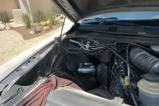 New starter motor installed deep within an engine bay in a Phoenix, AZ driveway.