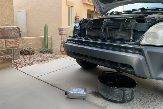 Technician performing a synthetic blend oil change on a car parked at a residential home in Phoenix, AZ.
