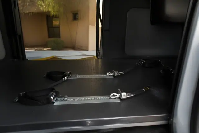 Wheelchair securement station with four-point tie-down straps in a medical transport vehicle in Phoenix, AZ.