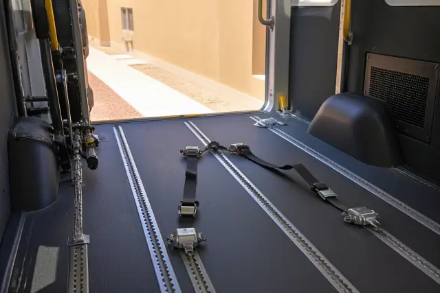 Heavy-duty four-point tie-down straps secured in a wheelchair station at a job site in Phoenix, AZ.