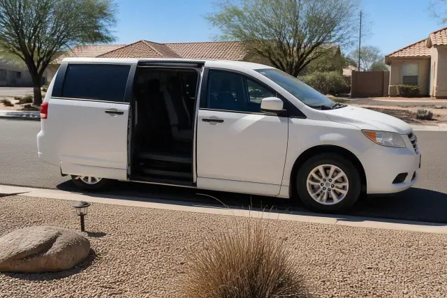 Ambulatory medical transport vehicle with open side doors for passenger boarding at a residential driveway in Surprise, AZ.
