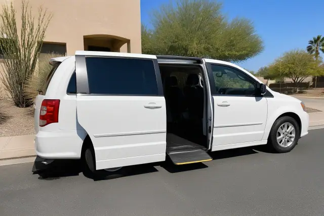 Medical transport van with open doors and passenger step deployed on a street in Phoenix, AZ.