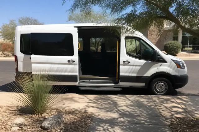 Ambulatory medical transport vehicle with open doors for passenger boarding at a curbside in Phoenix, AZ.