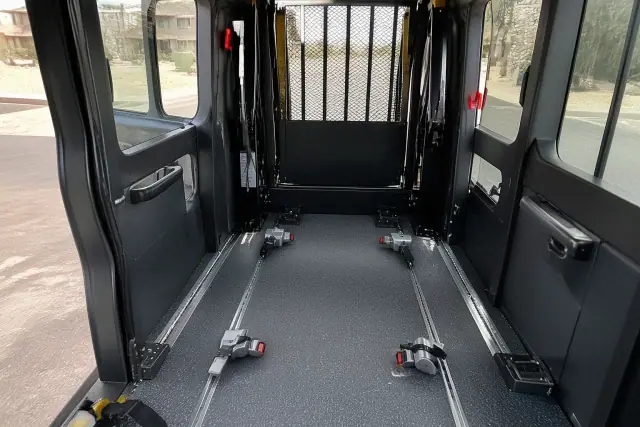 Wheelchair securement station with tie-down straps inside an ambulatory van in Phoenix, AZ.