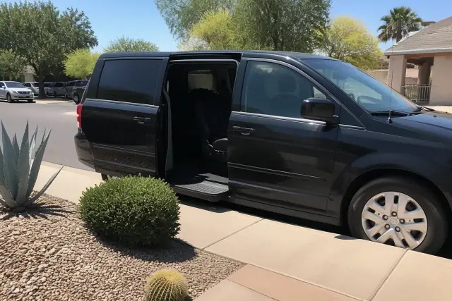 Medical transport vehicle with open side doors parked on a desert curb in Sun City, AZ.