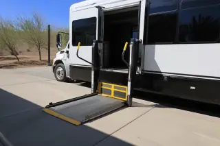 Automated hydraulic lift ramp lowered to the ground on a wheelchair transport van in Phoenix, AZ.
