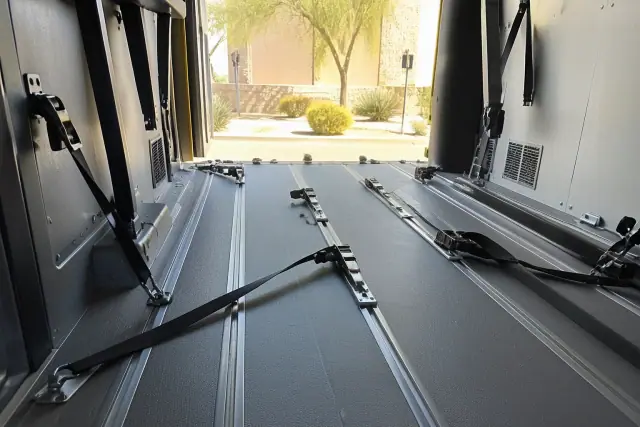 Interior of a medical transport vehicle with floor tracking systems and wheelchair tie-down straps in Phoenix, AZ.