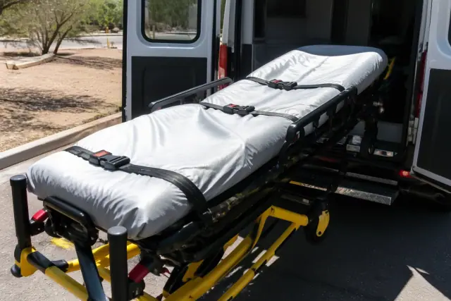 Bariatric stretcher with safety belts and locking mechanism being loaded into a vehicle in Phoenix, AZ.