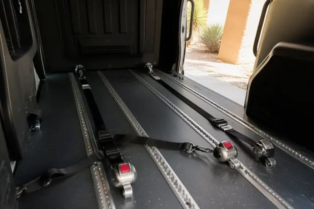 Interior of a bariatric transport vehicle showing heavy-duty wheelchair tie-downs in Phoenix, AZ.