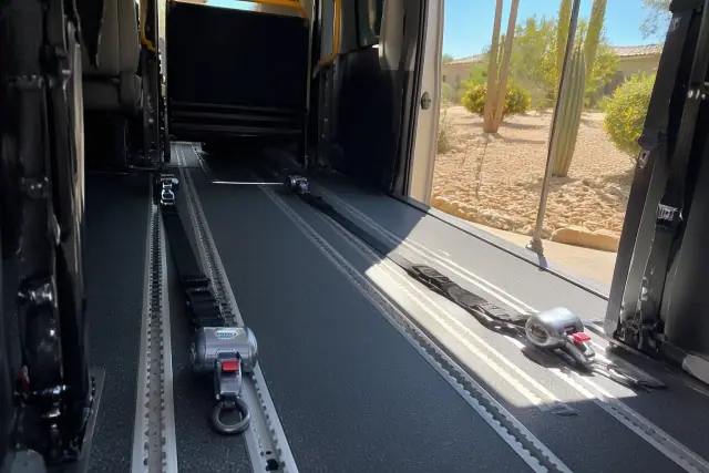 Interior of a wheelchair transport vehicle with floor-integrated tie-down straps in Phoenix, AZ.