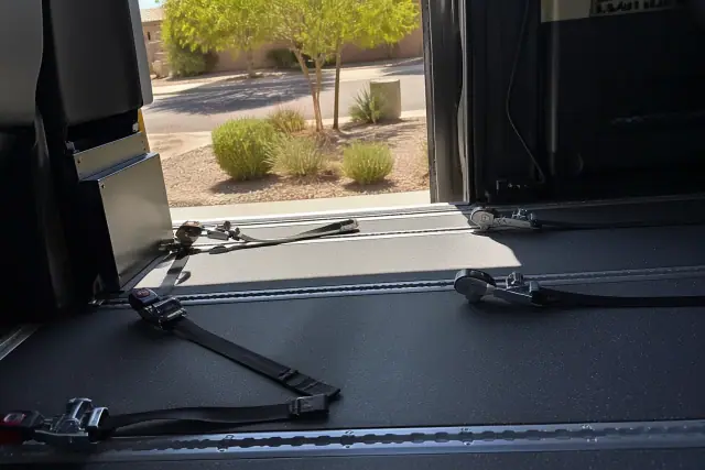 Wheelchair securement station with tie-down straps in a medical transport vehicle in Gilbert, AZ.