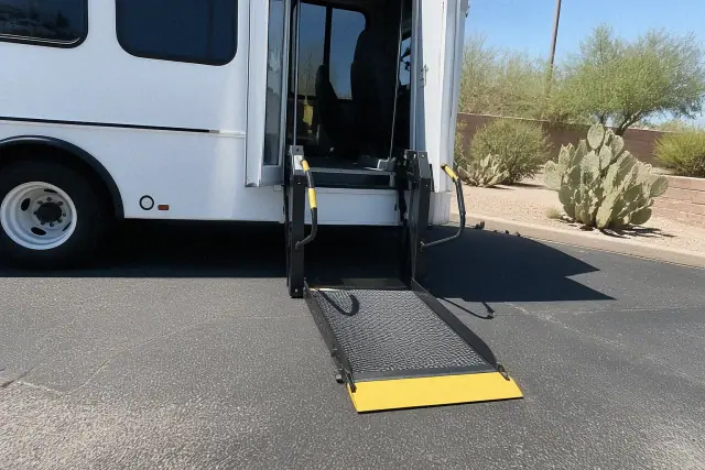 Automated hydraulic lift ramp deployed for bariatric medical transport on asphalt in Mesa, AZ with desert landscaping.