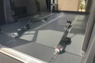 Heavy-duty tie-down straps and floor tracking systems installed in a bariatric transport van in Phoenix, AZ.