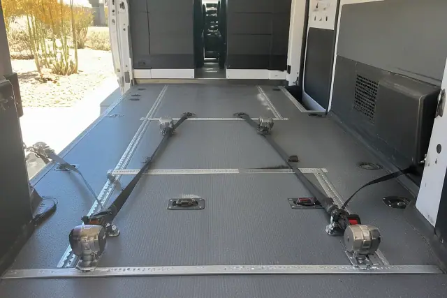 Heavy-duty wheelchair tie-down straps and floor tracking systems inside a bariatric transport van in Phoenix, AZ.
