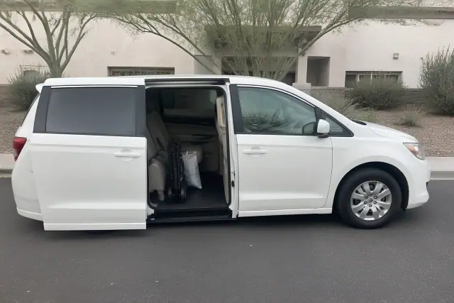 Medical transport van with open doors parked at a medical office in Phoenix, AZ.