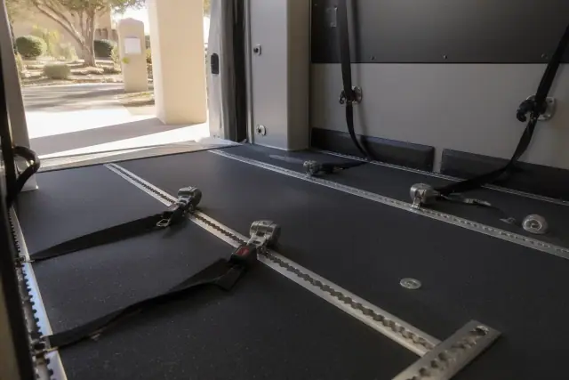 Interior of a medical transport vehicle with wheelchair tie-down straps and tracking systems in Chandler, AZ.