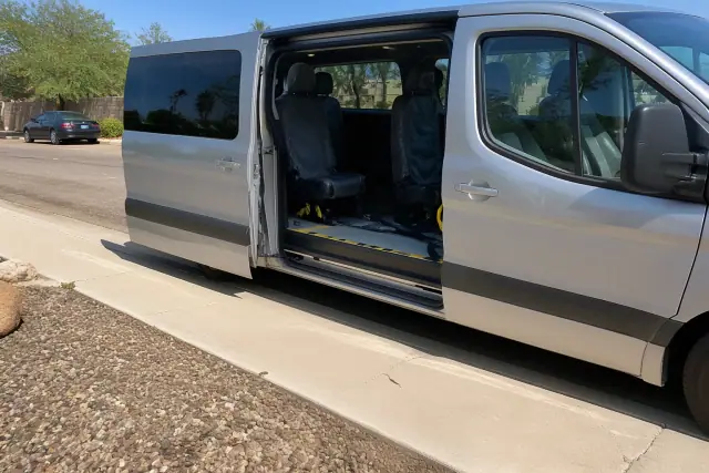 Transport van parked curbside for dialysis patient boarding in Phoenix, AZ.
