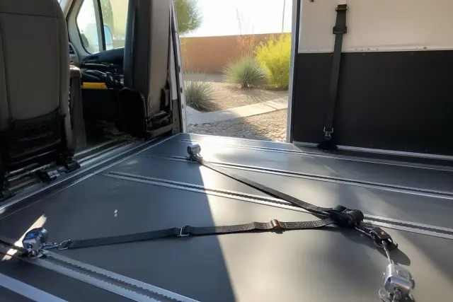 Interior of a dialysis transport vehicle with securement straps and desert landscaping visible in Phoenix, AZ.
