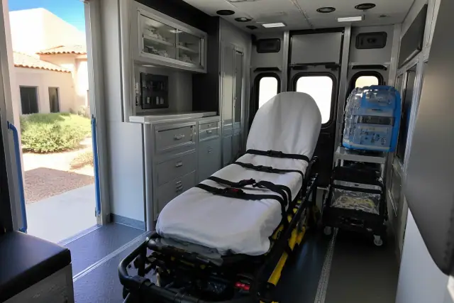 Interior of a dialysis medical transport vehicle cabin in Phoenix, AZ, showing equipment and safety restraints.
