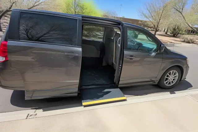 Wheelchair van with open sliding door and ramp at a dialysis clinic in Phoenix, AZ.