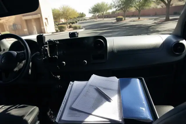 Dialysis trip documents and schedule on a transport vehicle dashboard in Phoenix, AZ.