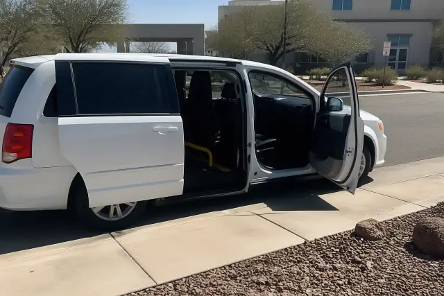 A vehicle with open sliding doors for medical transport on a street in Phoenix, AZ.