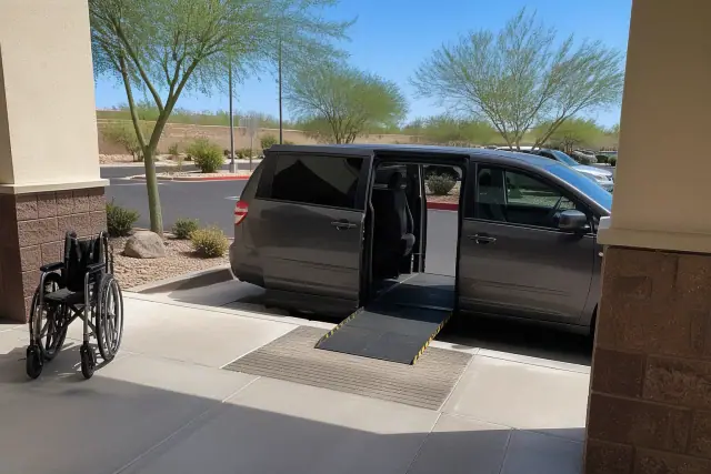 Van with open sliding door and ramp at a medical clinic entrance in Phoenix, AZ.