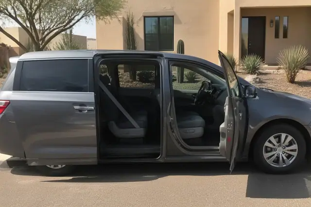 Transportation vehicle with open doors for curbside passenger boarding assistance at a residence in Phoenix, AZ.