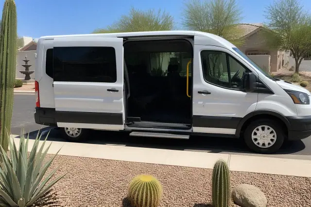 Professional transport van with open doors parked at a residential curb in Phoenix, AZ.