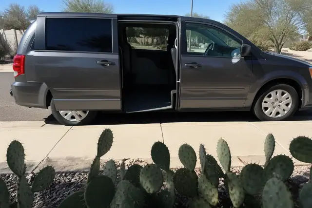 Medical transport van with sliding doors open for curbside pickup in a desert landscape in Chandler, AZ.