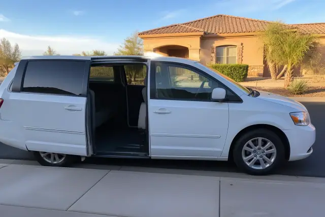 Medical transport vehicle with open side doors for curbside passenger boarding at a residence in Avondale, AZ.