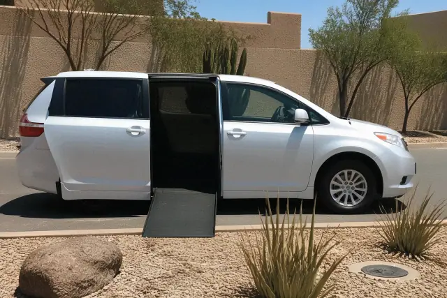 Wheelchair accessible vehicle with side doors open for boarding on a driveway in Phoenix, AZ.