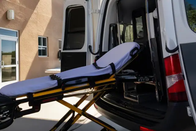 Stretcher secured at the rear doors of a transport vehicle during a patient loading procedure in Phoenix, AZ.