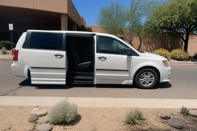 Medical transport vehicle with open side doors at a curbside pickup location in Mesa, AZ.