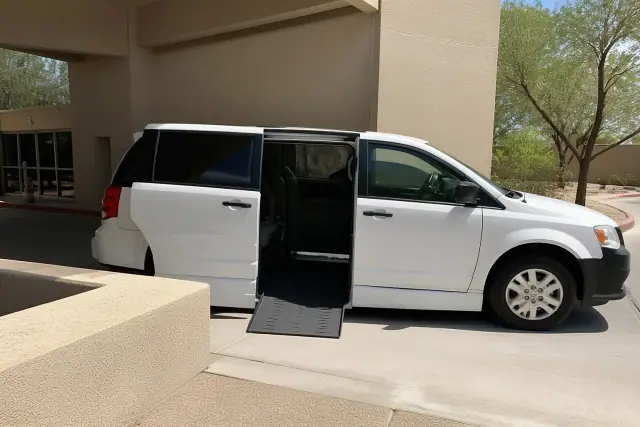 Medical transport vehicle with open side doors at a curb in Tempe, AZ.