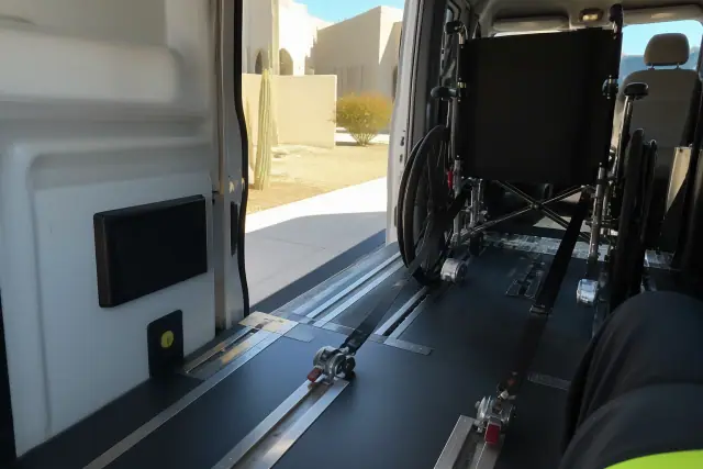Wheelchair securement straps inside a transport van with desert views in Phoenix, AZ.