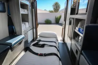 Folded linens and organized safety straps inside a medical transport van cabin in Phoenix, AZ.