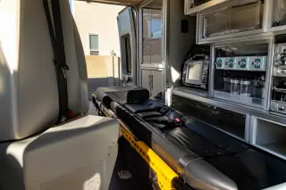 Organized medical transport cabin with storage cabinets and safety belts in Phoenix, AZ.