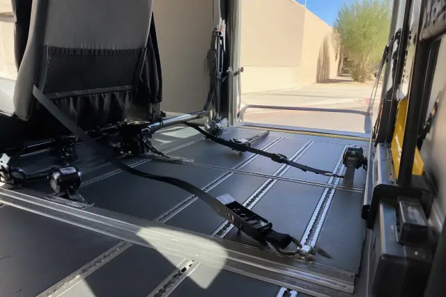 Interior of an ambulatory transport vehicle with wheelchair tie-down straps in Phoenix, AZ.