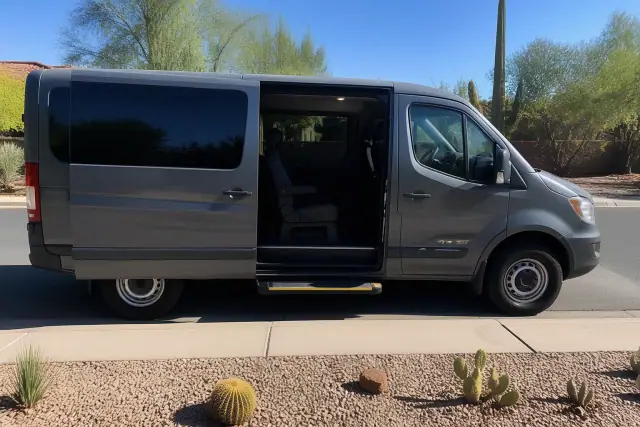 Medical transport van with sliding doors open for boarding on a residential street in Phoenix, AZ.