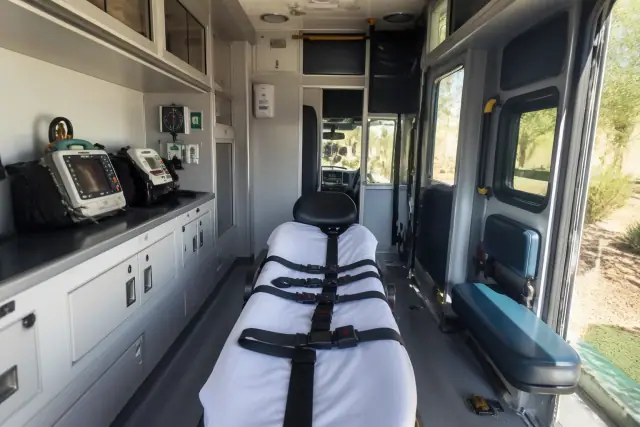 Interior of a medical transport ambulance showing equipment and safety restraints in Tempe, AZ.
