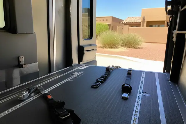 Wheelchair securement station with tie-down straps inside a medical transport van in Avondale, AZ.