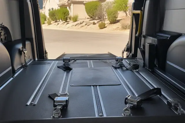 Wheelchair securement station with four-point tie-down straps inside a vehicle in Phoenix, AZ.