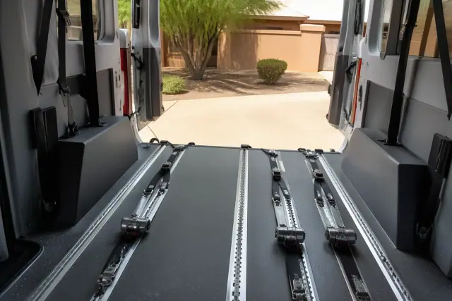 Interior of a medical transport vehicle with wheelchair tie-down straps and tracking systems in Phoenix, AZ.