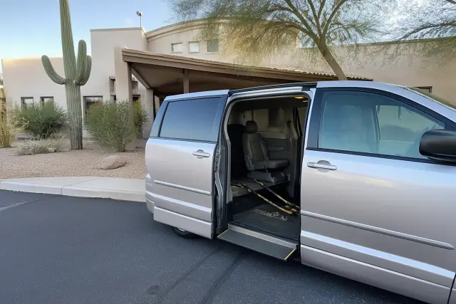 Accessible transport van with open side door and wheelchair straps at an outpatient clinic in Scottsdale, AZ.
