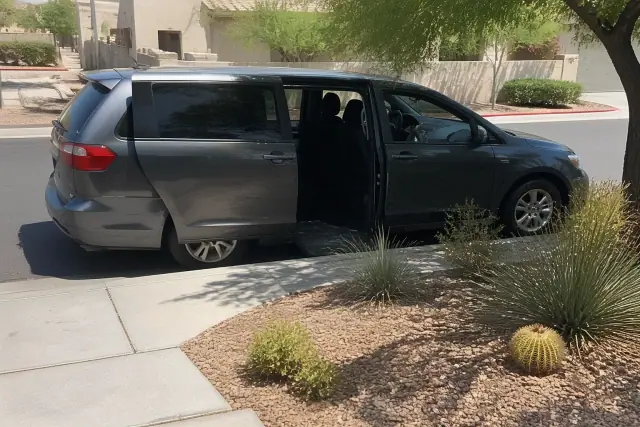Medical transport vehicle with open doors at a curbside pickup in Phoenix, AZ, on a sunny day.