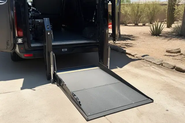 Automated hydraulic lift ramp lowered to the ground for mobility access at a desert venue in Phoenix, AZ.
