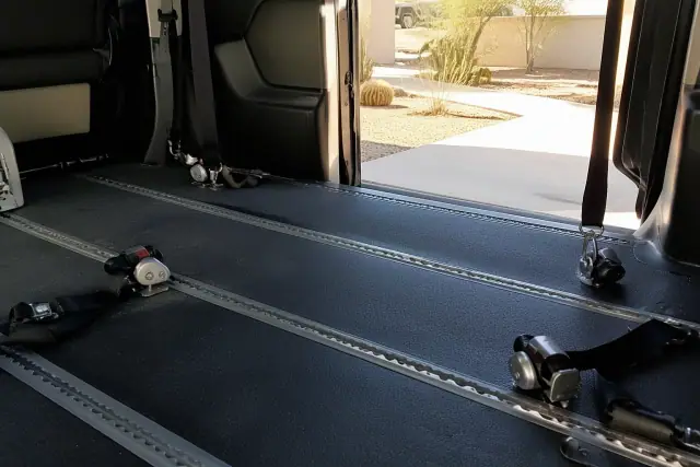Interior of a transport van with wheelchair tie-down straps and tracking systems in Phoenix, AZ.